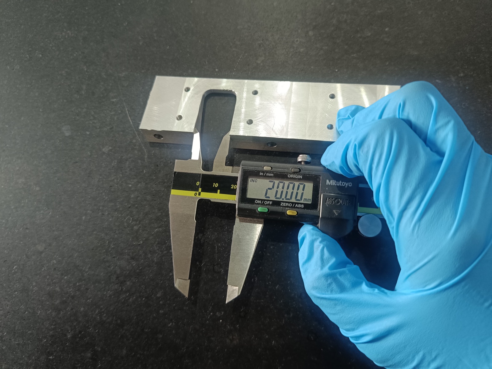 Precision inspection of a CNC machined aluminium part with a digital calliper